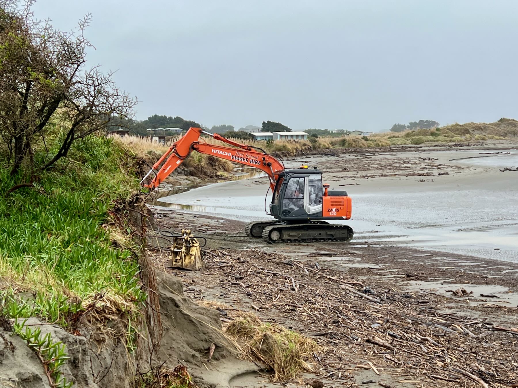 The digger works on the beach end of the track. 