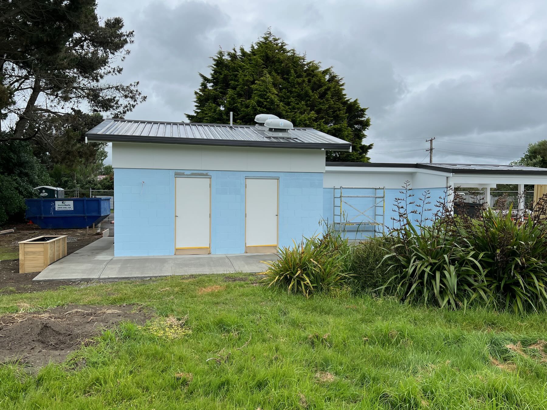 View from the Reserve, showing doors, shower area with scaffolding, concrete ramp and planter box. 